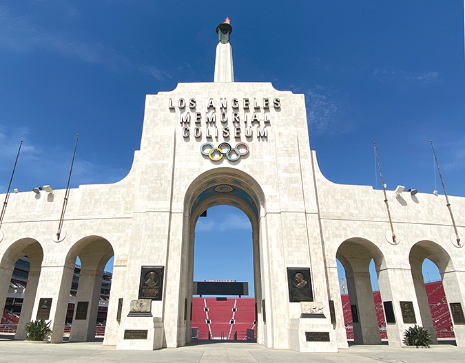 The main entrance of Los Angeles Memorial Coliseum under a blue sky