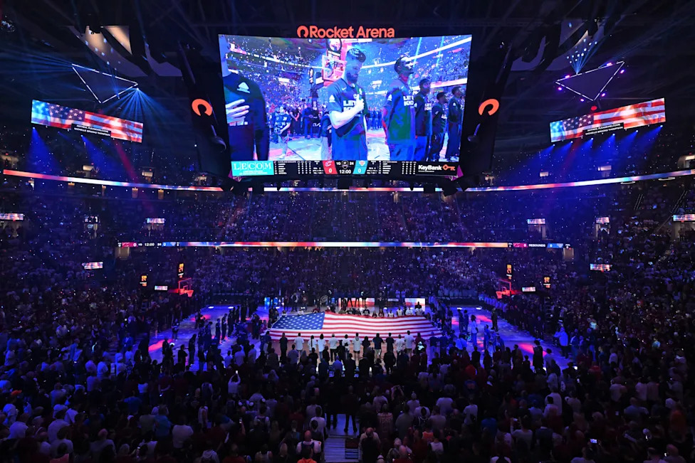 Indoor basketball arena illuminated in purple during a large NBA event