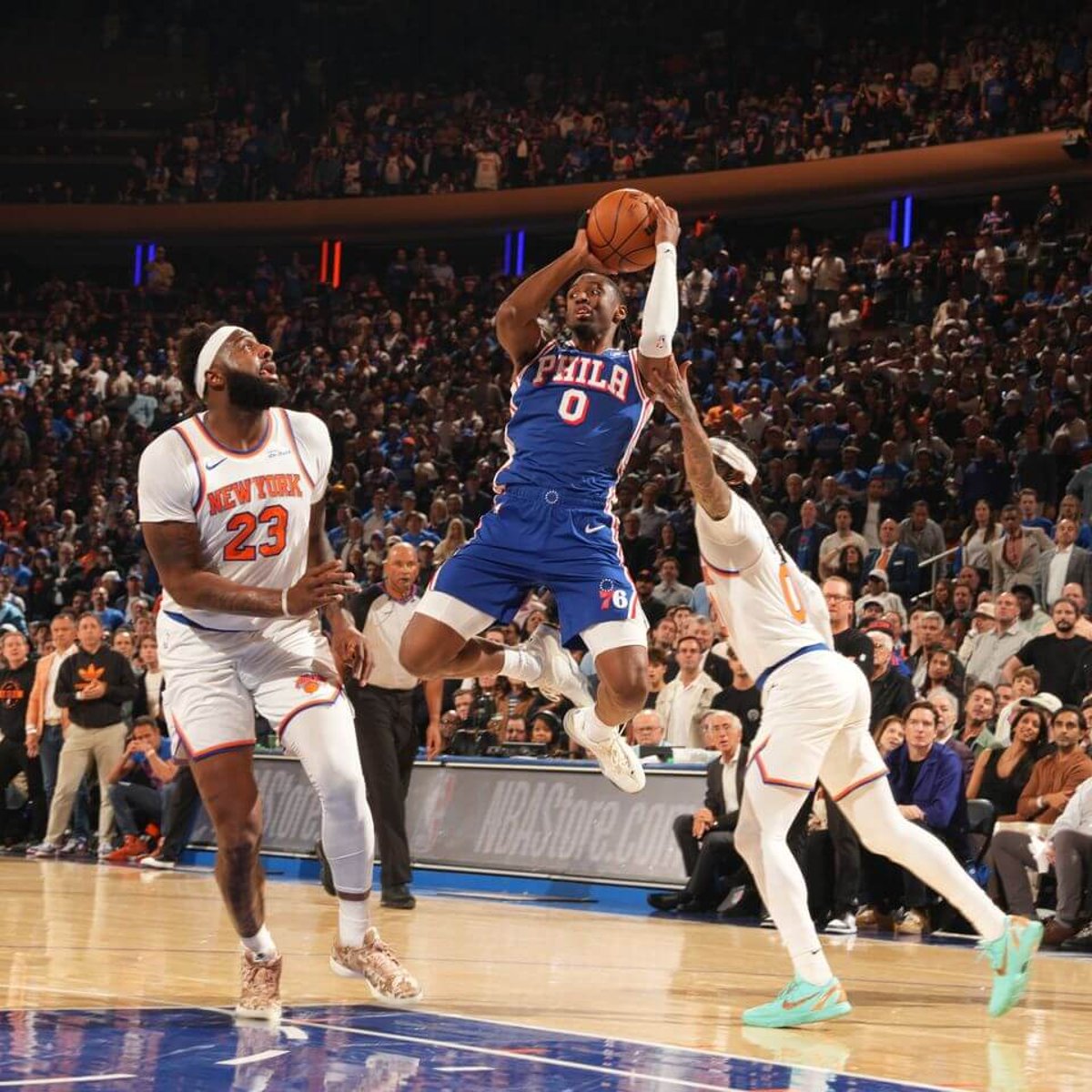 Professional basketball players defending a drive to the basket